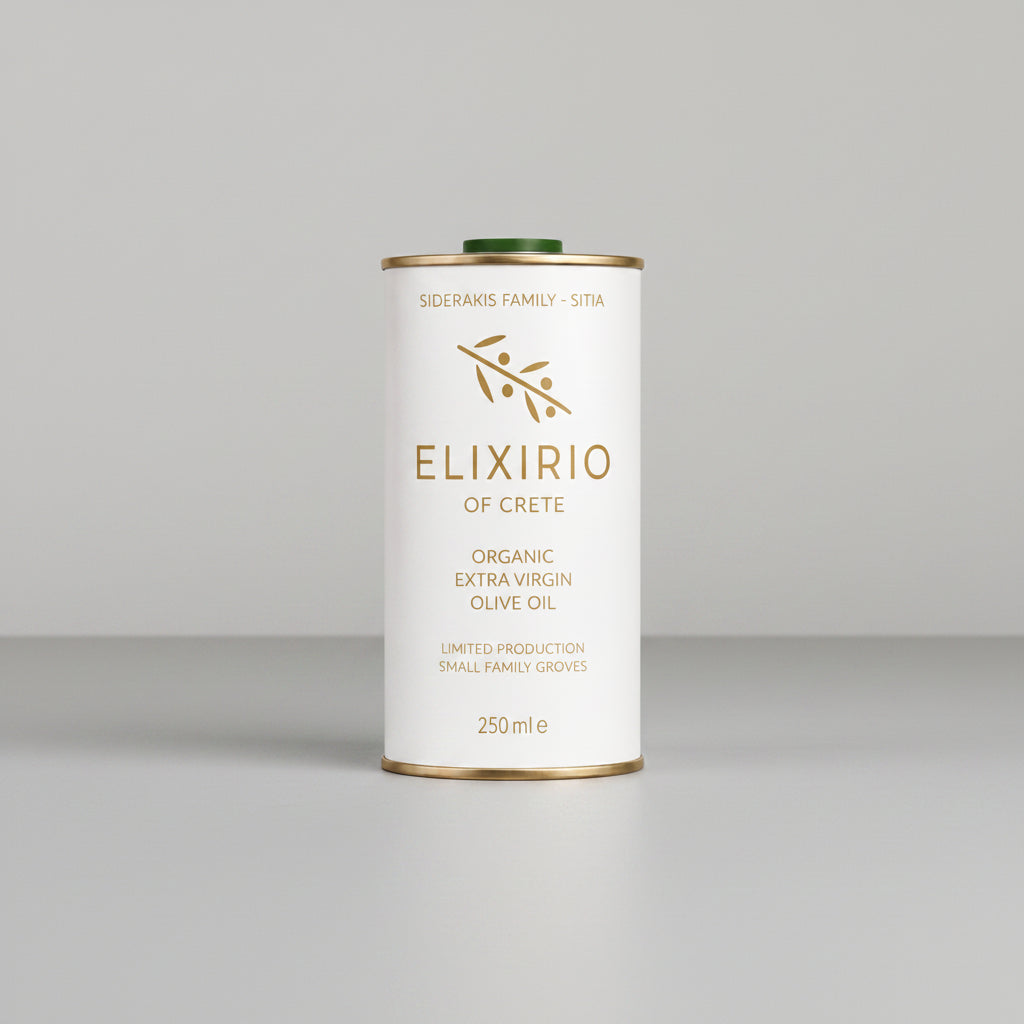 A 250ml metal can of Elixirio of Crete Organic Extra Virgin Olive Oil, featuring a white label with gold lettering and a green cap, centered on a plain white background.
